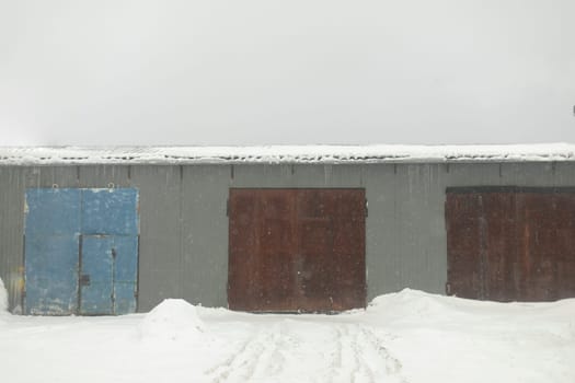 Hangar in winter. Rusty gates. Workshop is outside. Industrial zone. Entrance to territory.