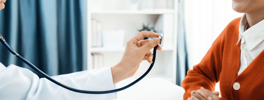 Patient attend doctor's appointment at clinic or hospital office. Doctor examining and diagnosis symptoms while checking the patient's pulse with stethoscope. Panorama Rigid