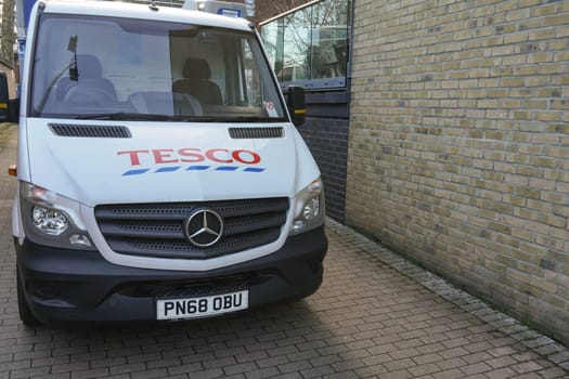 London, United Kingdom - February 03, 2019: White Tesco delivery van parked in small street, British supermarket offers food and groceries deliveries to home address anywhere in UK.