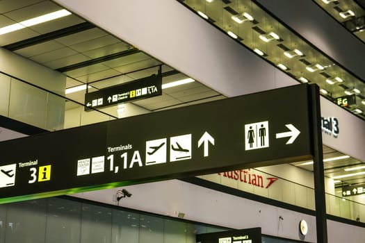 Schwechat, Austria - April 22, 2019: Navigation signs at terminal 3 building of Flughafen Wien airport, Austrian airlines (which has main base at Vienna) sign in background