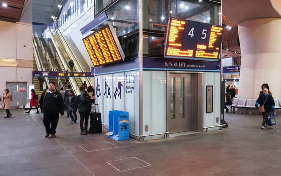 London, United Kingdom - February 01, 2019: Passengers walking under departure boards and lift at London Bridge station. It is fourth busiest in UK capital, serving 50 million people annually