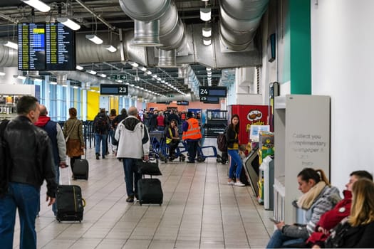 London, United Kingdom - February 05, 2019: Passengers walking to boarding gate, some waiting seated, at Luton airport. LTN is UK fifth busiest with 16.5 million passengers transported in 2018