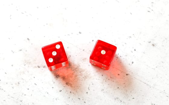 Two red craps dices showing Easy Four (number 3 and 1) overhead shot on white board