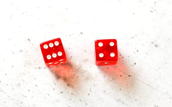 Two red craps dices showing Easy Ten (number 6 and 4) overhead shot on white board