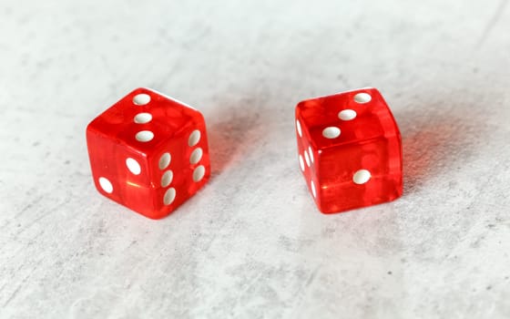 Two translucent red craps dices on white board showing Hard Six (double number three)