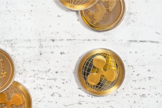 Flat lay photo, ripple cryptocurrency  XRP golden coins on white stone desk.