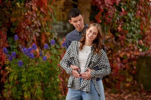 Young Cute Female Hugs Boyfriend. In Autumn Outdoor. Lovers Walking in Park. Attractive Funny Couple. Lovestory in Forest. Man and Woman. Cute Lovers in the Park. Family Concept. Happy Couple.