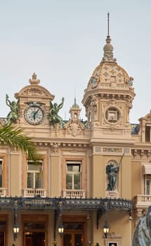 Monaco, Monte-Carlo, 21 October 2022: Facade of Casino Monte-Carlo at sunny day, wealth life, famous landmark, pine trees, blue sky. High quality photo