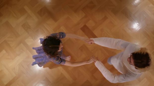 Pair dancing indoors. Stock. A young couple in outfits dancing in a quiet home atmosphere holding hands. High quality 4k footage