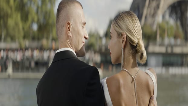 A kissing European couple. Action. A young beautiful blonde woman with her man kissing on the background of the Eiffel Tower. High quality 4k footage