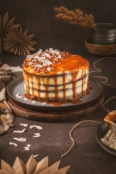 Delicious caramel cake with small pieces of pecan nuts and coconut shavings.