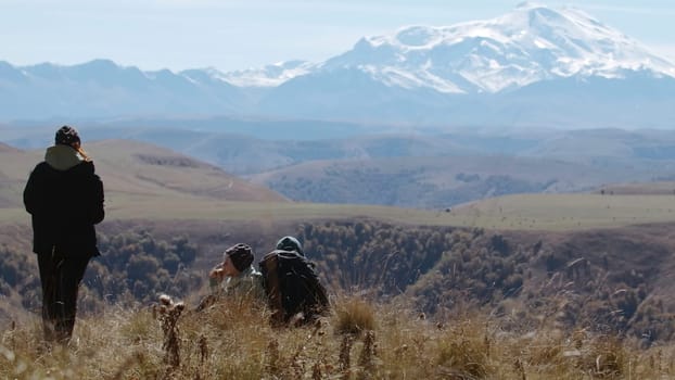 Family of tourists on a journey admire the view of the mountains. Creative. Hikers on a mountain top