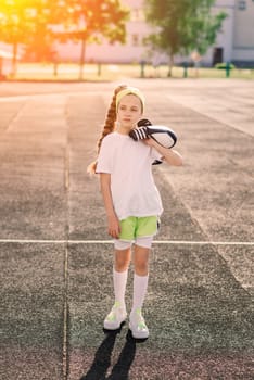 Girl jogging on a sunny summer evening, laying on treadmill, stadium, physical training, back to school, tired.