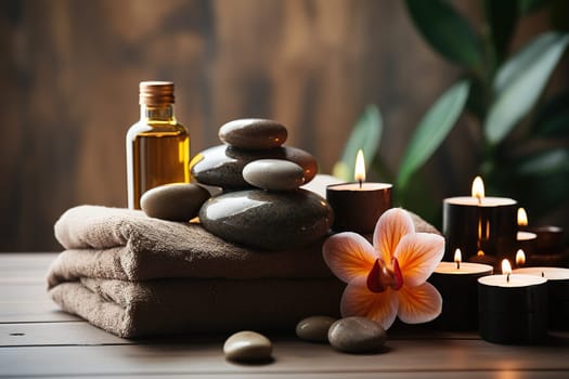 Towels with massage stones on a wooden table with flowers and candles. Comfort of a spa salon.