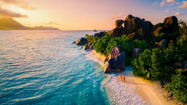 Anse Source d'Argent La Digue Seychelles, a couple of Caucasian men and Asian women on a tropical beach during a luxury vacation in Anse Source d'Argent La Digue Seychelles