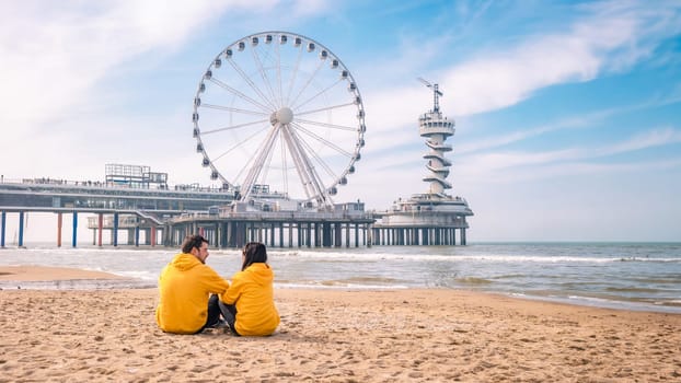 couple on the beach of Scheveningen Netherlands during Spring, The Ferris Wheel at The Pier at Scheveningen in the Netherlands, Sunny spring day at the beach