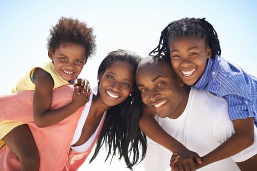 Black family, parents or children on piggyback at beach for adventure, holiday or vacation in summer. African people, face or smile outdoor in nature for break, experience or bonding and relationship.