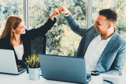 Success business partner - Businesswoman and businessman celebrating together in modern workplace office. People corporate teamwork concept. uds