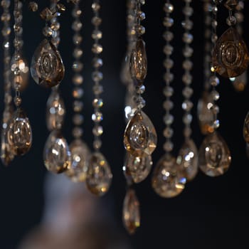 Crystal on a chandelier close-up on a dark background, reflection of light from the crystal.