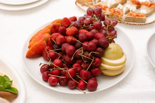 Fruit serving plate, vitamins in the form of fresh cherry fruit, various fruits.
