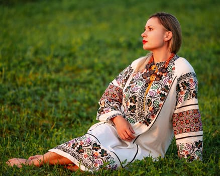 Embroidered and unique petticoat, a girl walks barefoot in the field in an embroidered shirt, Ukrainian clothes and traditions.