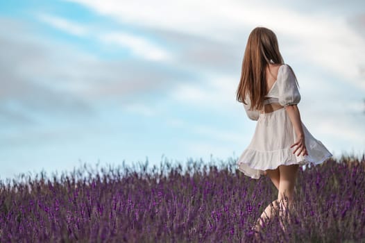 A beautiful girl walks in a white dress in a lavender field, aromatherapy in a lavender field.