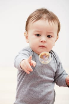 Baby, bubbles and playing game for fun childhood development, curious wondering or education. Kid, growth and mockup space for learning progress or sensory, coordination skill or youth entertainment.