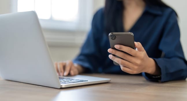 Woman search information from the internet network. Business woman working with smartphone and laptop computer on table in home. network concept.