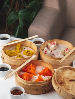 Dim Sum Dishes Set. Traditional Asan brunch dish. Steamed dumpling food with soy sauce on restaurant table background. Dim sum Traditional Chinese and Japanese food.