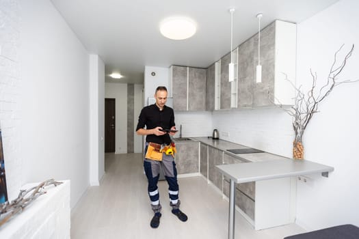 Worker with tablet computer checking alarm system indoors. High quality photo