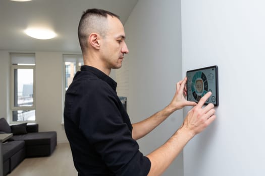 Worker with tablet computer checking alarm system indoors. High quality photo