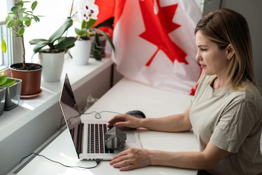 beautiful smiling woman covered in canadian flag looking at camera isolated on white. High quality photo