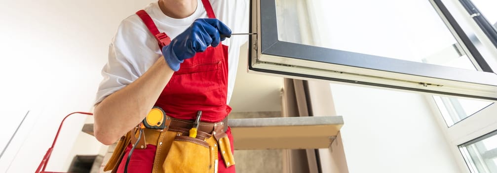 Construction worker installing window in house.