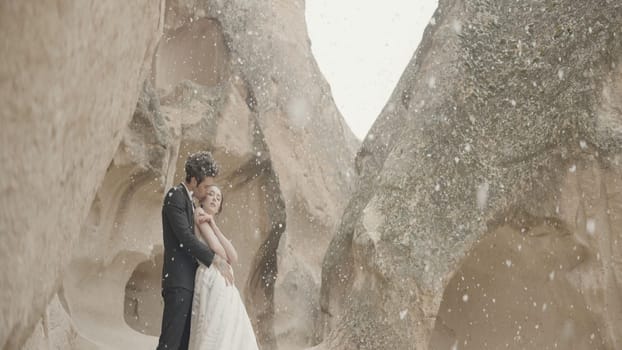 Beautiful love story photo session. Action.A young couple in nature in suits are photographed against the backdrop of mountains with warm weather. High quality 4k footage