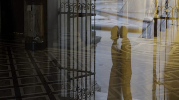 Detailed wedding photography. Action. The silhouette of the kissing newlyweds and their walk down the street in classic costumes. High quality 4k footage