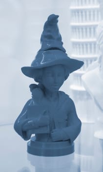Prototype of art object 3D printed from melted blue plastic. Model of girl in a hat created 3D printer. New innovation modern 3D printing technology. Additive progressive technology