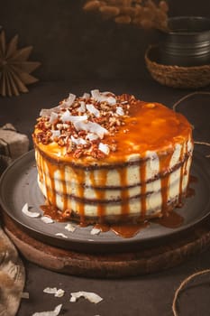 Delicious caramel cake with small pieces of pecan nuts and coconut shavings.