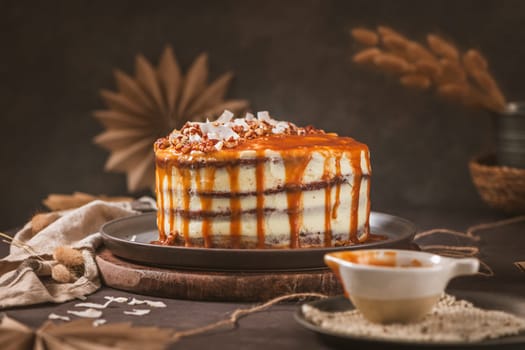 Delicious caramel cake with small pieces of pecan nuts and coconut shavings.