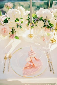 Knotted napkin lies on a plate on a set table. High quality photo