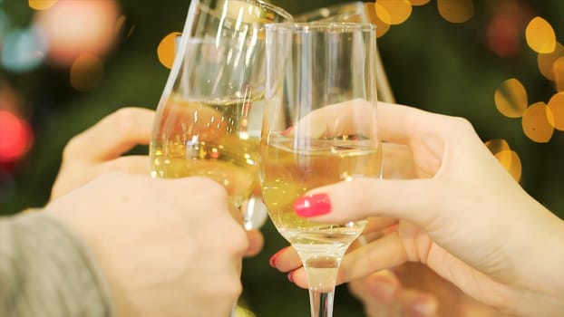 Celebration or party. People holding glasses of champagne making a toast. Clinking glasses of champagne in hands on bright lights background.