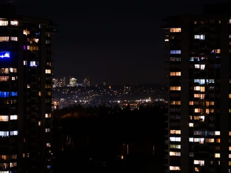 City night view. Residential building on a winter night. Eluminated windows of high-rise residential buildings