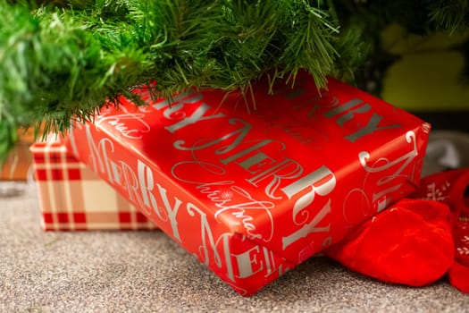 Christmas gifts laying underneath of fir tree branches