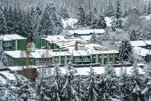 Campus of low-rise buildings covered in snow. Residential area in front of Christmas holidays