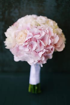 Bridal pink bouquet stands on the floor against the wall. High quality photo