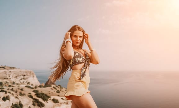 Woman travel sea. Happy tourist taking picture outdoors for memories. Woman traveler looks at the edge of the cliff on the sea bay of mountains, sharing travel adventure journey.