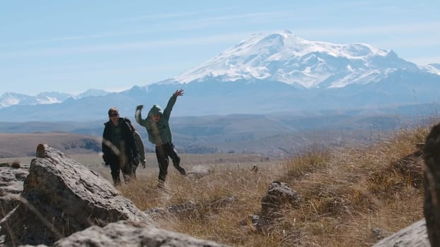 Carefree happy family hikers on mountain top on summer trip adventure. Creative. Family travel in mountainous region