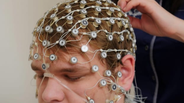 Tests at the hospital. Stock footage. A man to whom new equipment is attached to check the work of the brain. High quality 4k footage