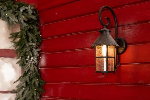 Old Christmas lantern in evening on wooden background.