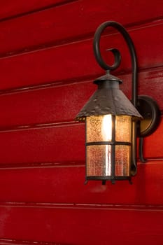 Old Christmas lantern in evening on wooden background.