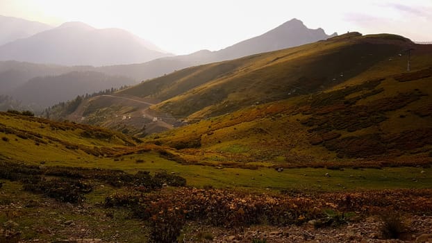 A view of a valley with mountains in the background. The sun shines on the mountains in the distance, featured on unsplash, superflat, panorama, creative commons attribution